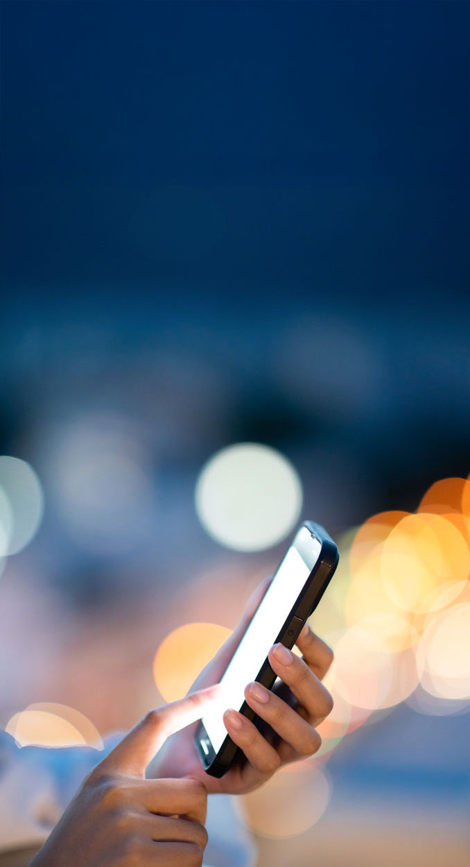 woman using mobile phone in the night city lights background.